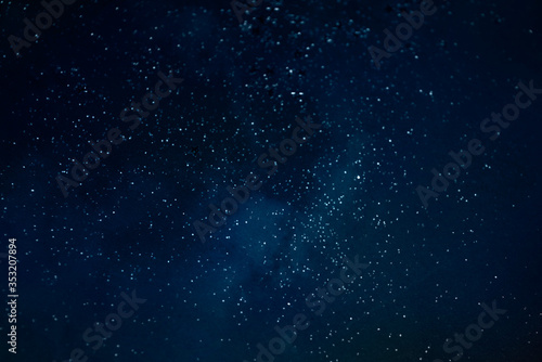 Bokeh light background. Holiday glowing backdrop. Defocused Background With Blinking Stars. Blurred Bokeh.