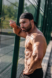 Sexy fitness sportsman posing on a sports field topless. Fitness, bodybuilding, healthy lifestyle