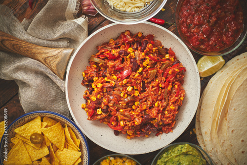 Preparing vegetable burritos on white pan. With various ingredinets for mexican food photo