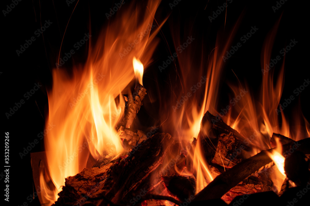 A hot orange fire burning brightly on a dark night A hot orange fire burning brightly on a dark night