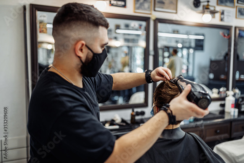 Barber makes a haircut and hair styling in a barbershop, beauty salon. 