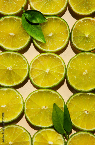 Lime slices background with green leaves
