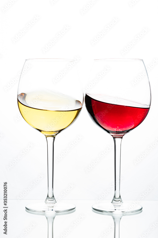 Two glasses with wine on a white background. Red wine. White wine. Apple juice. Cherry juice.