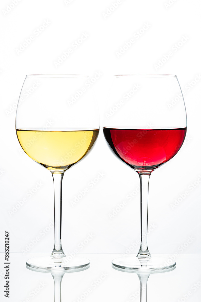 Two glasses with wine on a white background. Red wine. White wine. Apple juice. Cherry juice.