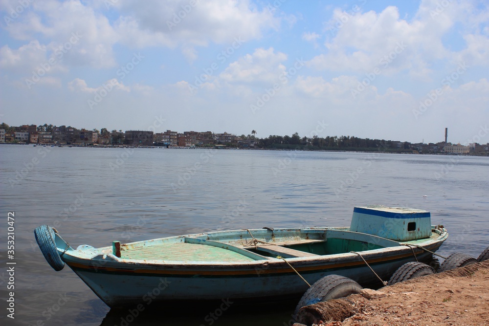 Empty small blue boat sitting on the Nile shore in Rosetta town  