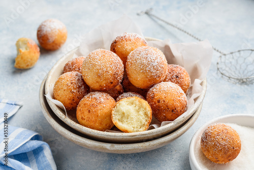 Billede på lærred Cottage cheese donuts balls with powdered sugar in a bowl on a blue background