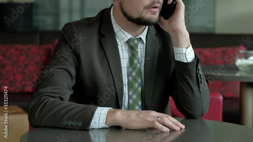 Businessman in eyeglasses talking on the mobile phone in office. 4k uhd photo