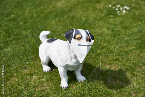 kitschy dog figure on lawn with kn95 protective mask