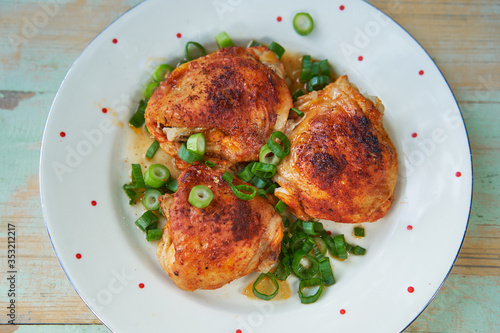 Close up Picture of vintage porcelain plate with roasted hot spicy chicken legs and chopped spring onion. Simple but tasty and juicy delicious light dish, with balanced nutritions and rich in protein.