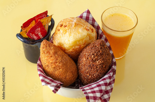 delicious brazilian snacks and fresh juice on a yellow table viewing from above