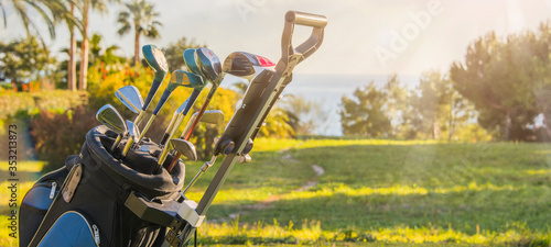 Golf clubs drivers over green field background