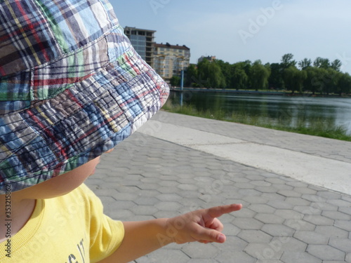 A small child in the summer on a walk near the lake