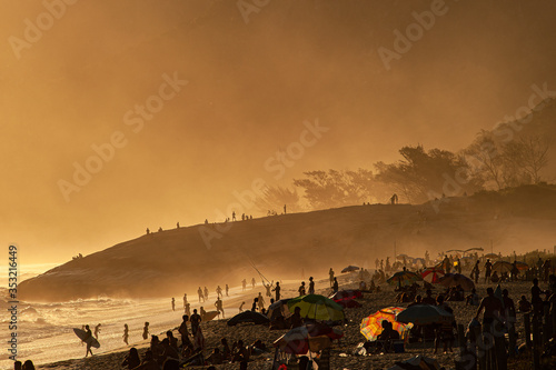 Many bathers at Recreio dos Bandeirantes beach, in Rio de Janeiro, Brazil, enjoying the sunset.