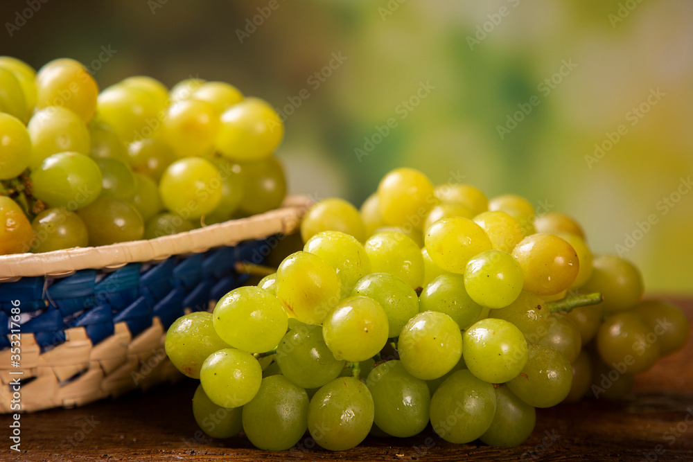 Bunch of green grapes, fruits of autumn, a symbol of abundance on rustic wood background. Bunch of green grapes, fruits of autumn, a symbol of abundance on rustic wood background.