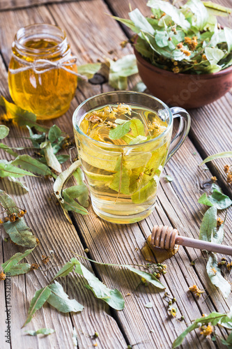 Harvesting healing herbs, linden flower tea and honey on a wooden background, alternative medicine