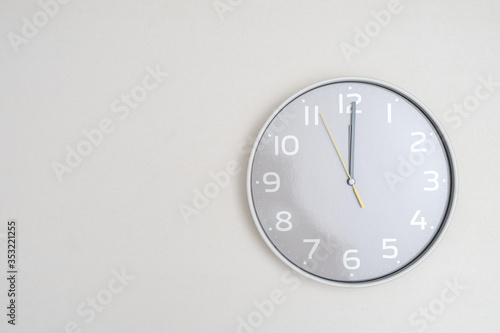 White clock hanging on white background
