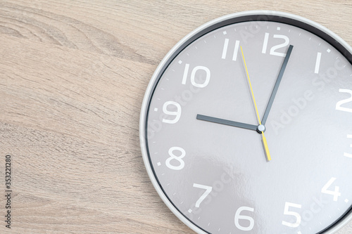 Close up White clock hanging on Wood background