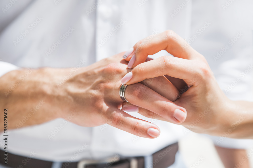 Obraz premium Bride and groom exchanging wedding rings close up during symbolic nautical decor destination wedding marriage on sandy beach in front of the ocean in Punta Cana, Dominican republic 