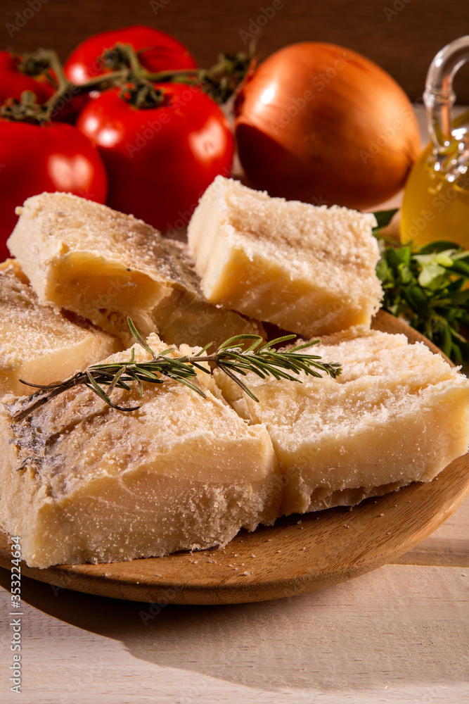 salted codfish on the wooden table with ingredients. Codfish raw.