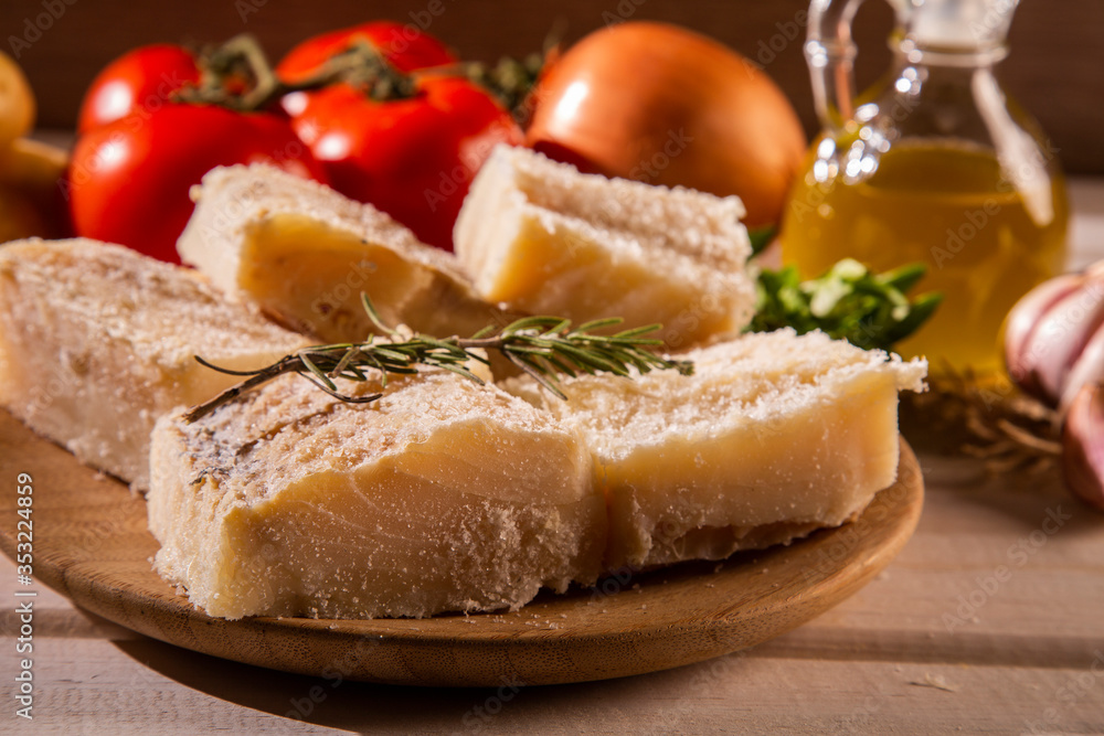 salted codfish on the wooden table with ingredients. Codfish raw.