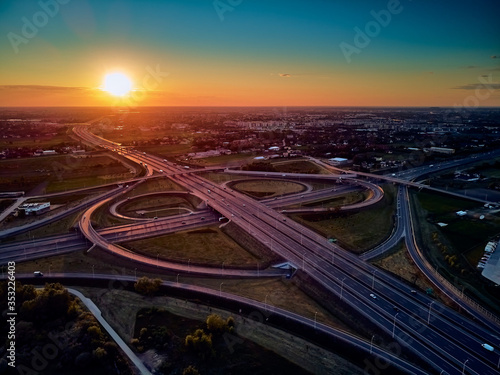 A beautiful panoramic aerial drone view of the sunset on the highway overpass of the southern Warsaw bypass (Polish: POW), Michalowice district in Warsaw, Opacz Kolonia, Poland © udmurd