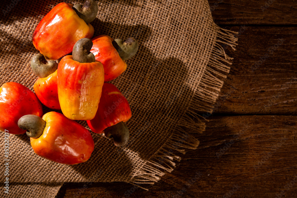 cashew fruit over a wooden surface.