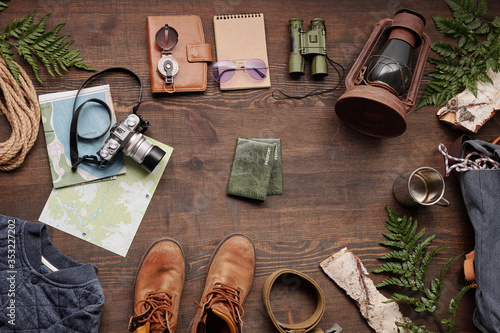 Above view of forest hiking stuff on dark wooden table for travelling abroad, flat lay