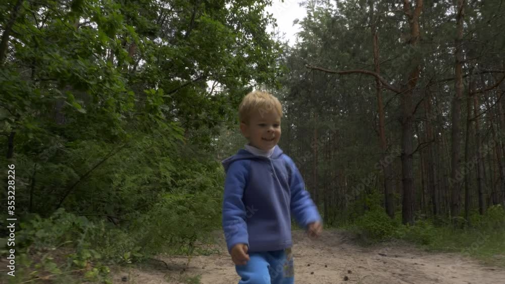 Little Boy Running Alone in the Forest. Lonely Child Wandering in the Wood. Summer Season Little Boy Running Alone in the Forest. Lonely Child Wandering in the Wood. Summer Season