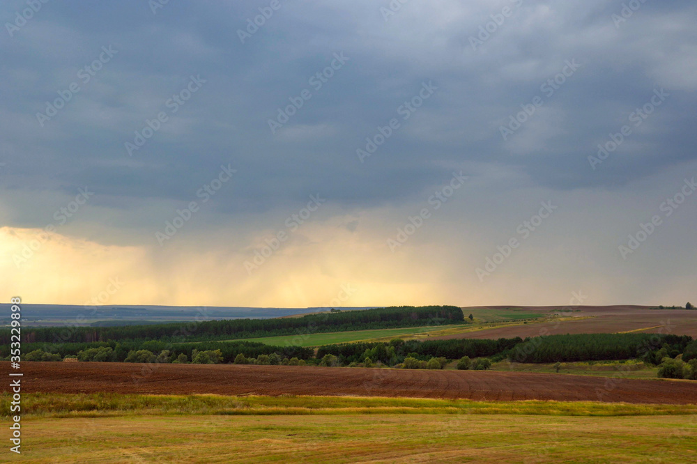 Thunderclouds and rain in the distance over Russian fields