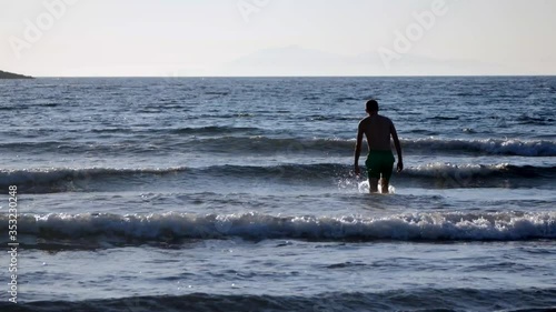 Young man is going to swim in the sea but it is not getting deeper photo