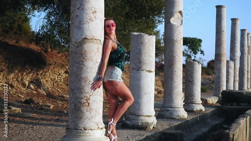 Woman tourist posing in colonnaded street of ancient greek agora in Side, Turkey photo