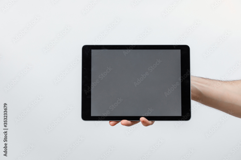hand holds a tablet with a white screen on a white background, isolated hand holds a tablet with a white screen on a white background, isolated