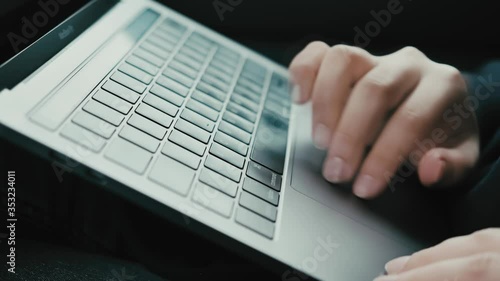 A girl works on a laptop in a car. It's raining. Color graded. 
Shallow depth of field.
