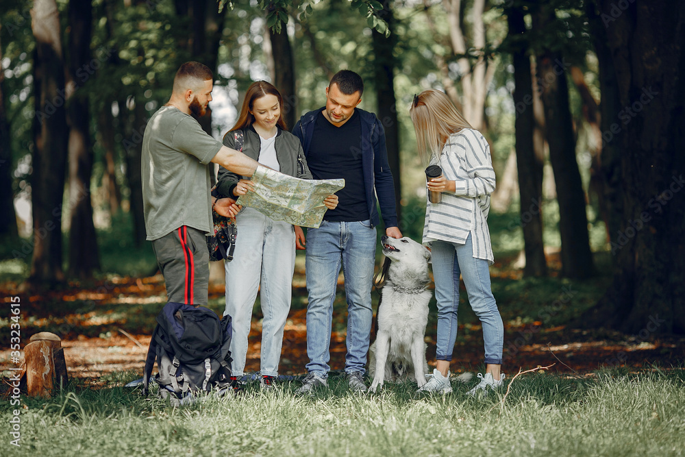 Tourists in a summer forest. Friends with a map. Tourists in a summer forest. Friends with a map.
