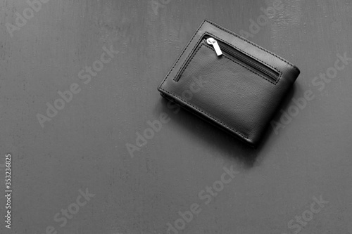 black leather wallet on a gray painted background