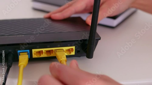 Woman connects the internet cable to the router's socket.