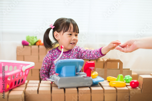 Konstfotografi toddler girl pretend play sweet shop keeper at home