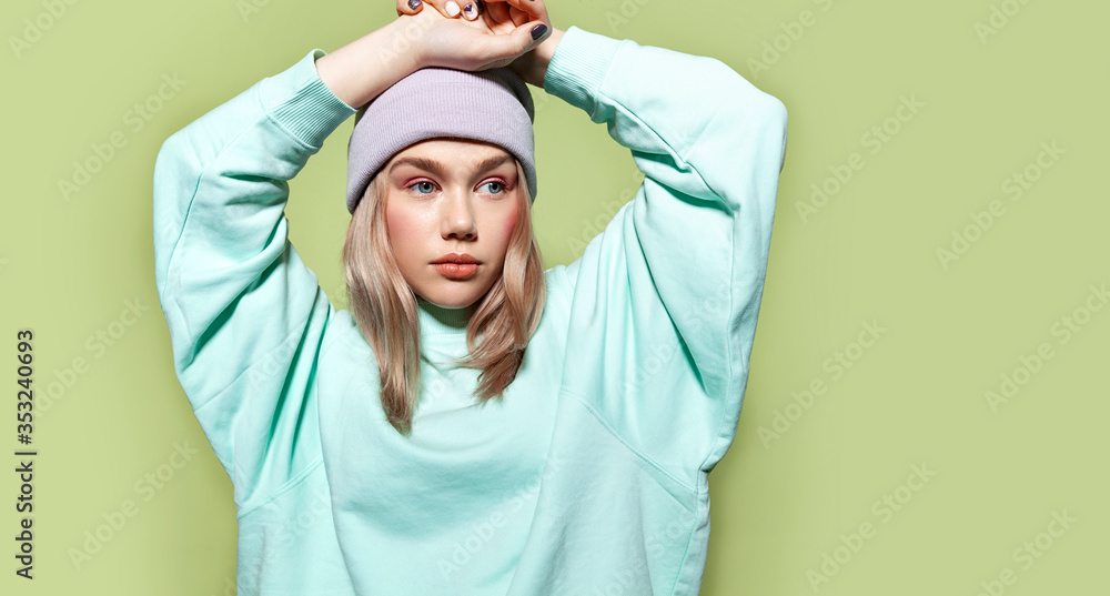 Young teenager model with stylish make up wearing casual blue sweatshirt and lavender hat. Young teenager model with stylish make up wearing casual blue sweatshirt and lavender hat.