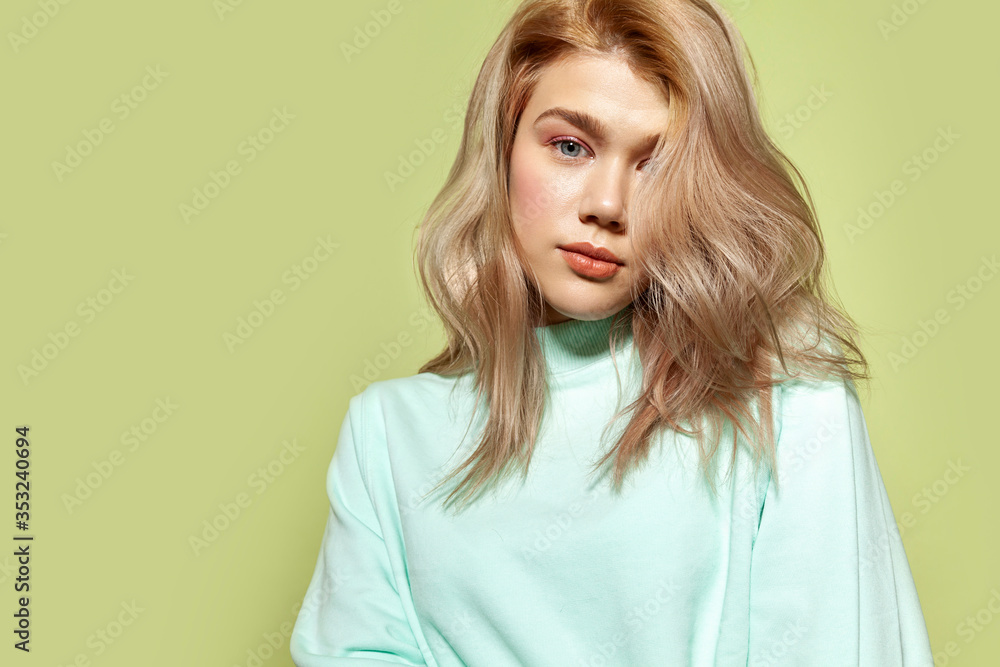 Fototapeta premium Fashion portrait of a beautiful girl with pastel pink make up and blue sweatshirt