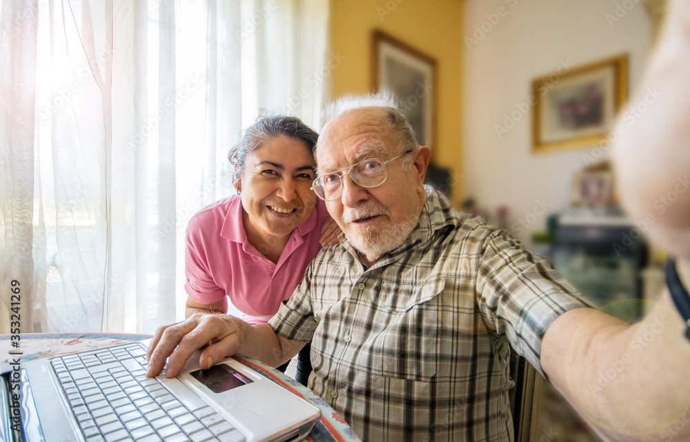 Elderly man with her caregiver taking a selfie photo at home Elderly man with her caregiver taking a selfie photo at home