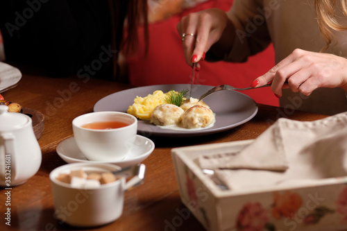 Female hands holding fork and knife  close Up. Woman eating business lunch  dinner at restaurant.