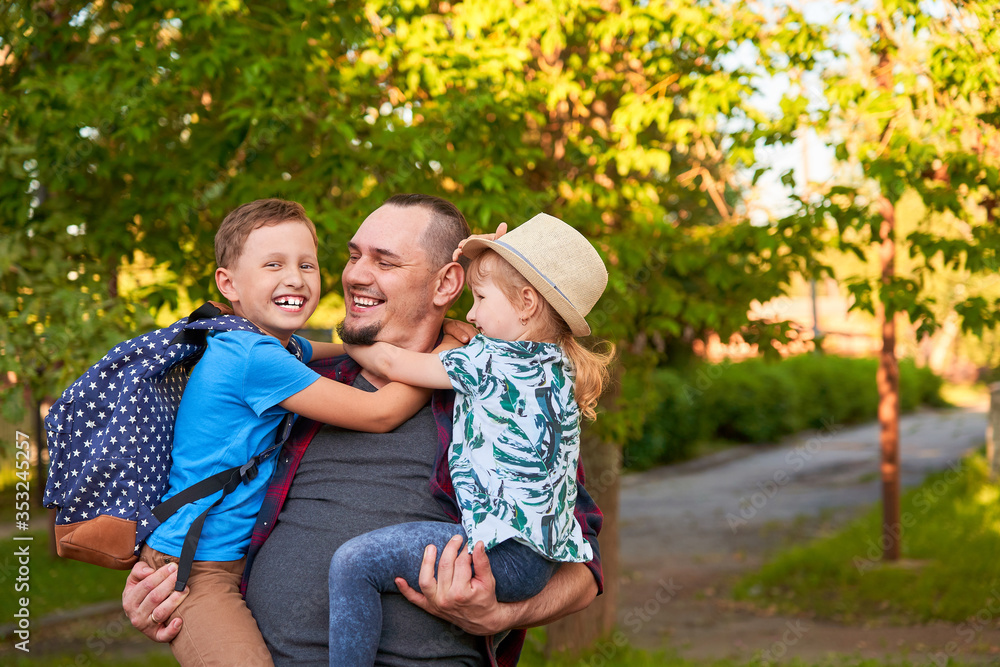 Fototapeta premium happy family of father and children.The father holds the children in his arms