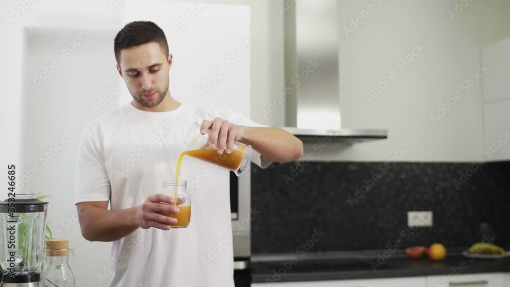 Man is pouring fresh juice into a jar Man is pouring fresh juice into a jar