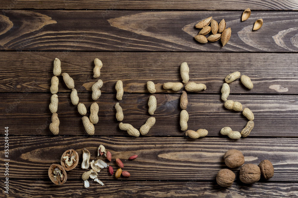 Nuts spelling nuts on a wooden table. Nuts spelling nuts on a wooden table.
