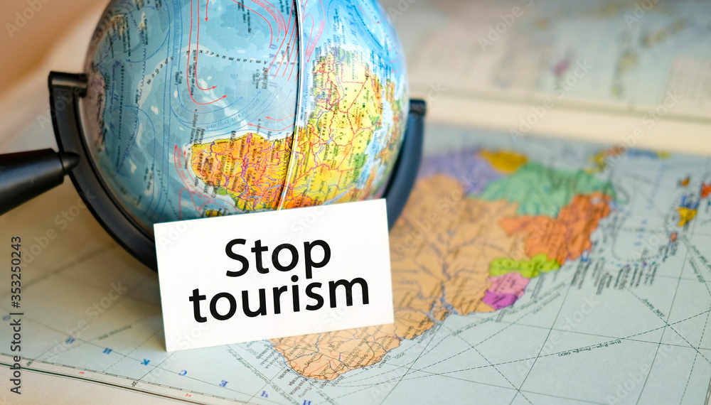 Stop tourism due to the crisis and pandemic, the termination of flights and tours for travel. Text in one hand on the background of the globe of America