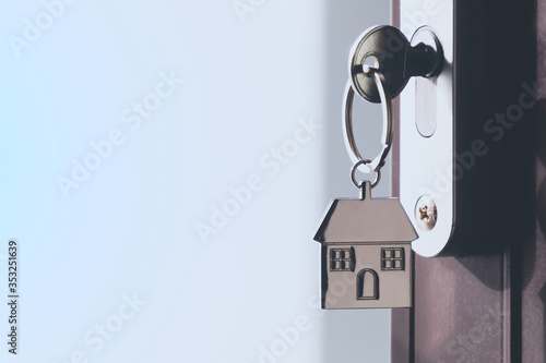 Canvas-taulu The home key with house keyring in the door keyhole with copy space