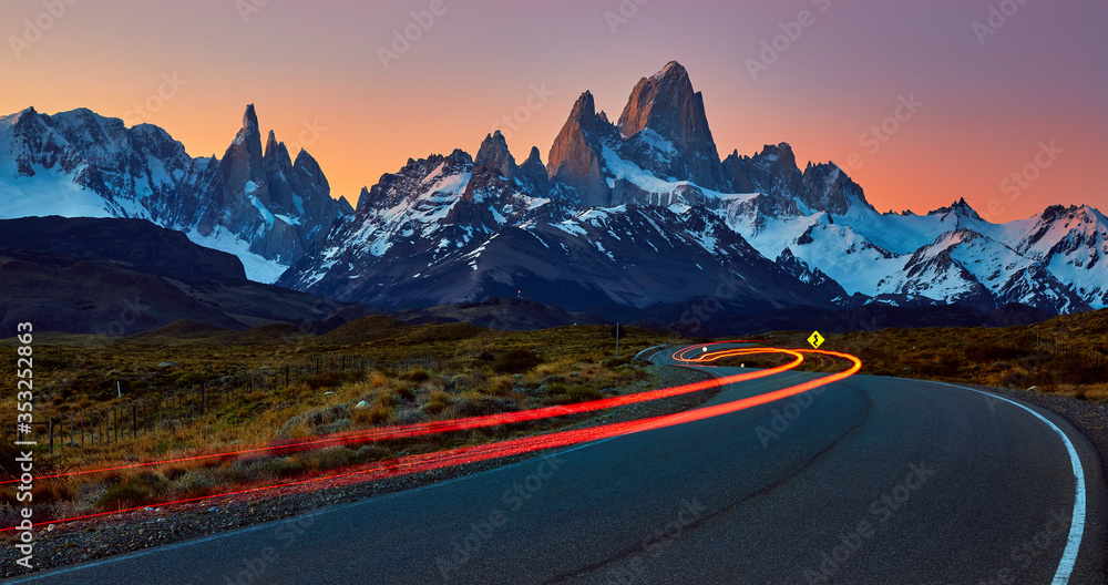 Fitz Roy and Torre massif, at sunset with car light trace on the road to El Chalten.