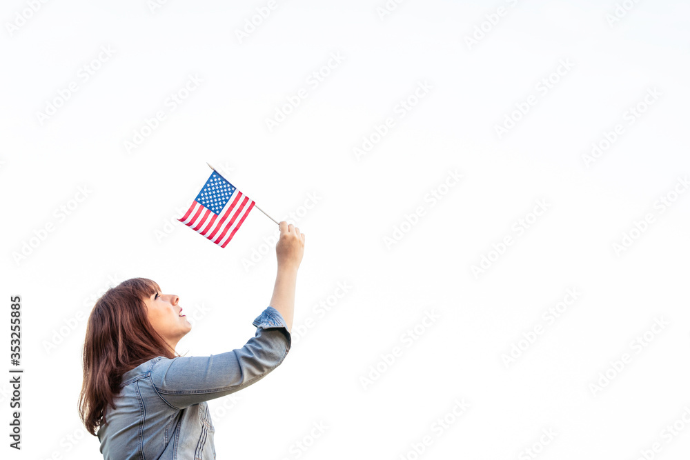 copy space. Woman hand with American swaying flag on the blue sky. isolated. America. USA. Concept. July 4 United States. copy space. Woman hand with American swaying flag on the blue sky. isolated. America. USA. Concept. July 4 United States.