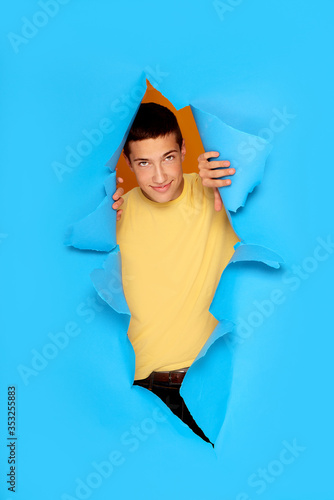 Smiling teenage boy over blue background. © neonshot