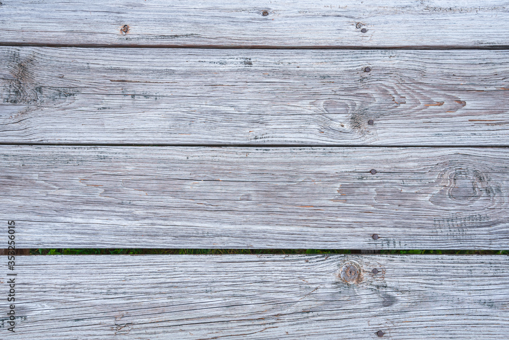 Naklejka premium Close up of the weather planks of a boardwalk. Useful as wooden background